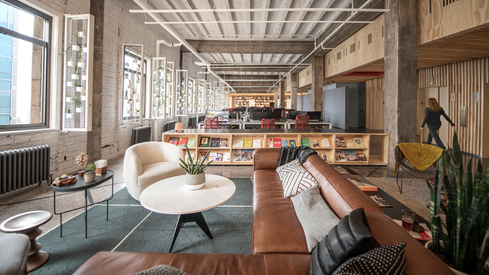 A person standing in a room with a bar and chairs.