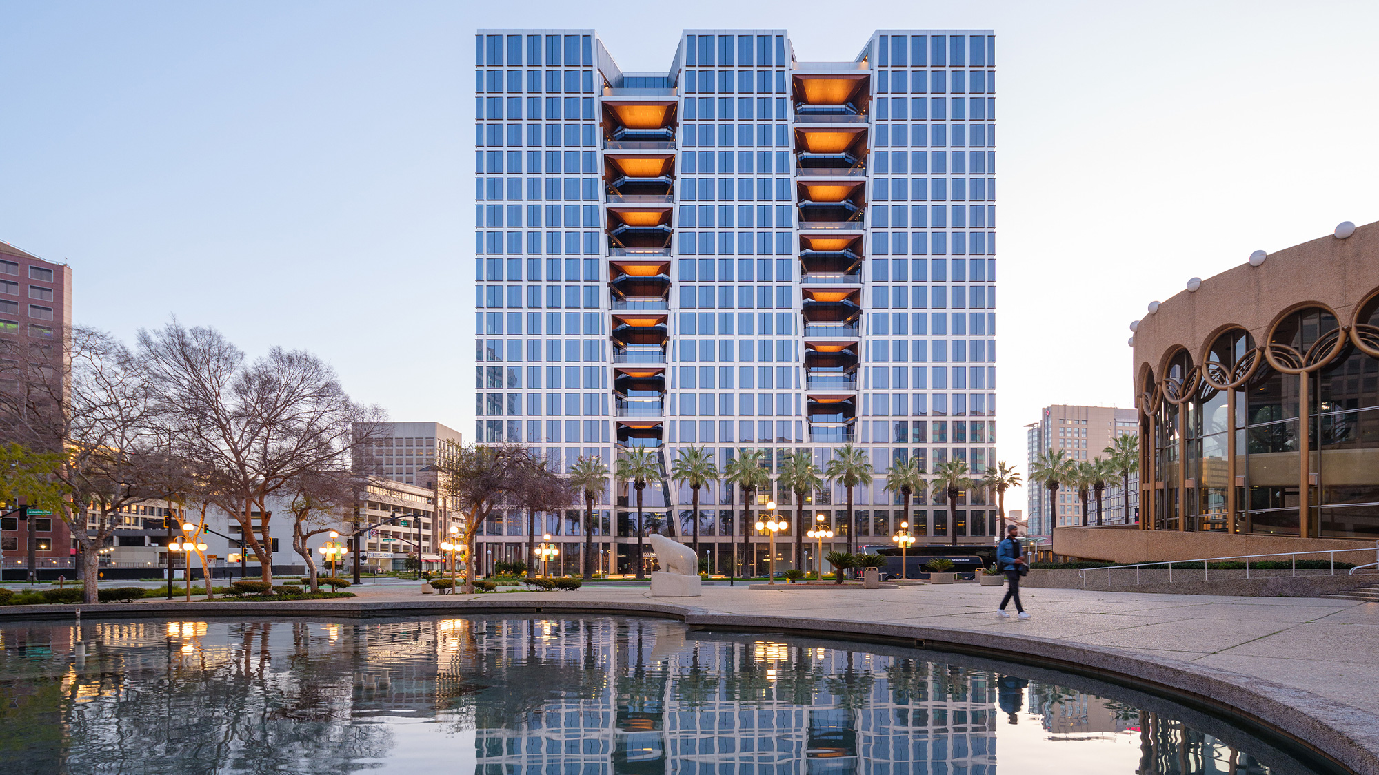 A large building with a pool in front of it.