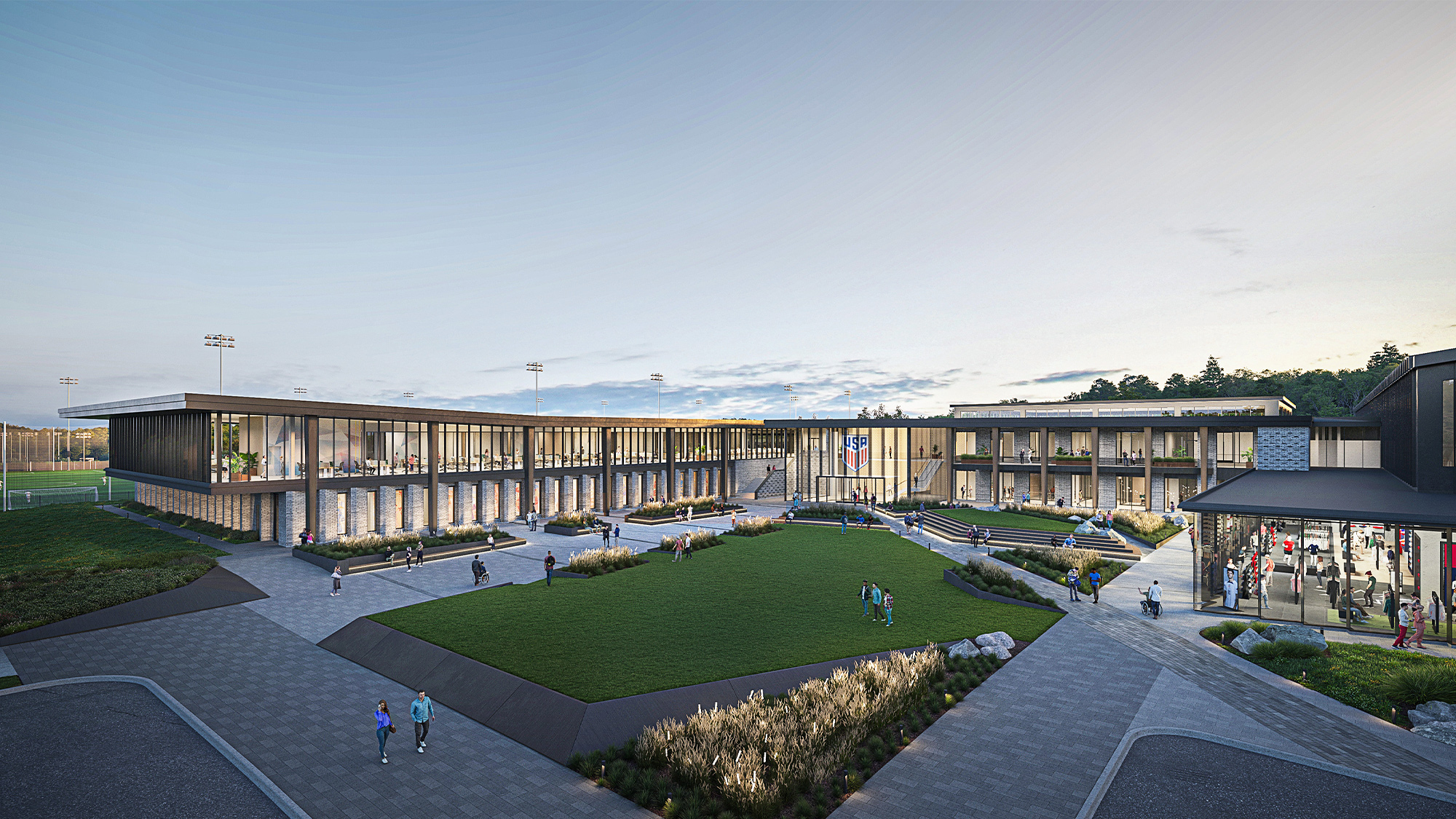 A large stadium with a field in front of it.