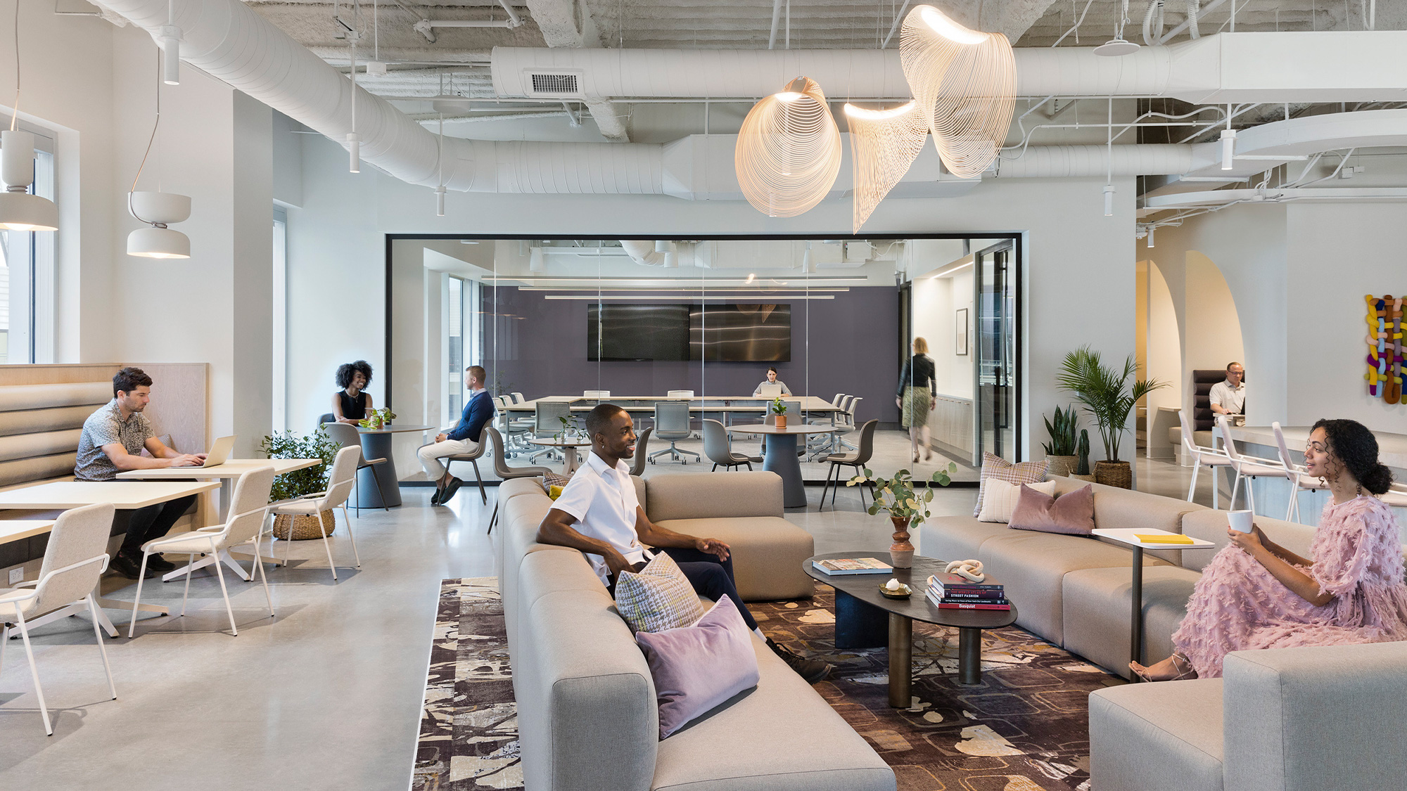 A group of people sitting in a room with a large chandelier.