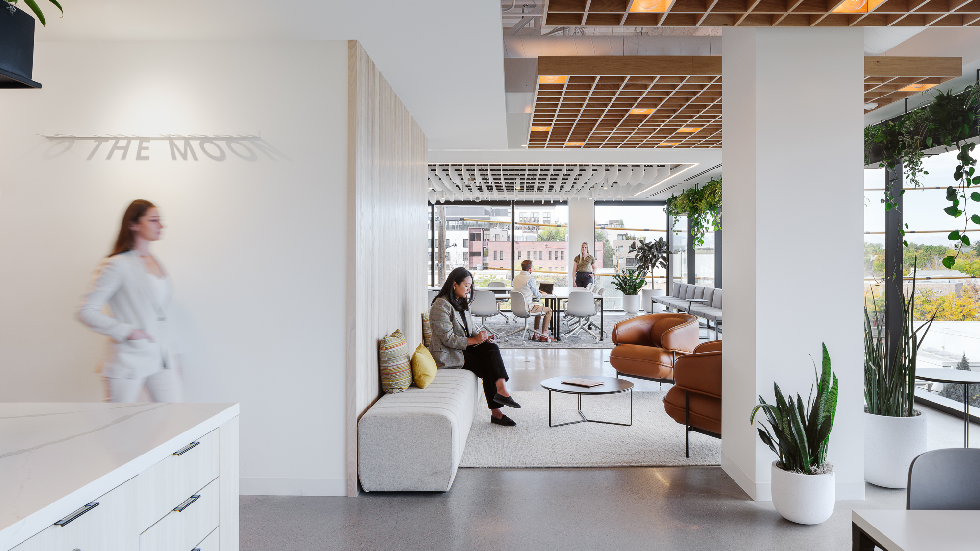 A woman standing next to a man sitting on a couch.
