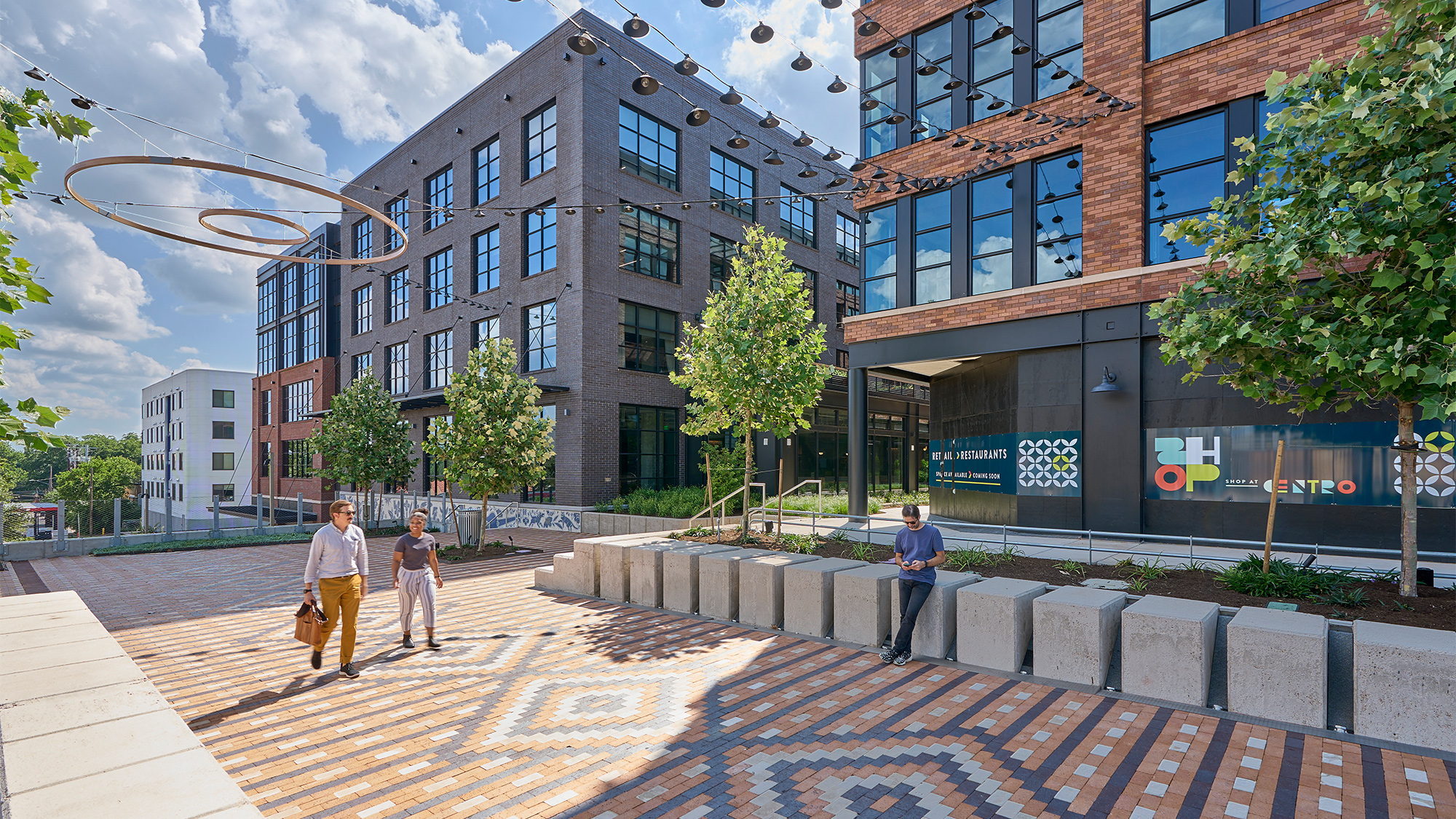 A group of people walking on a brick path in front of a building.