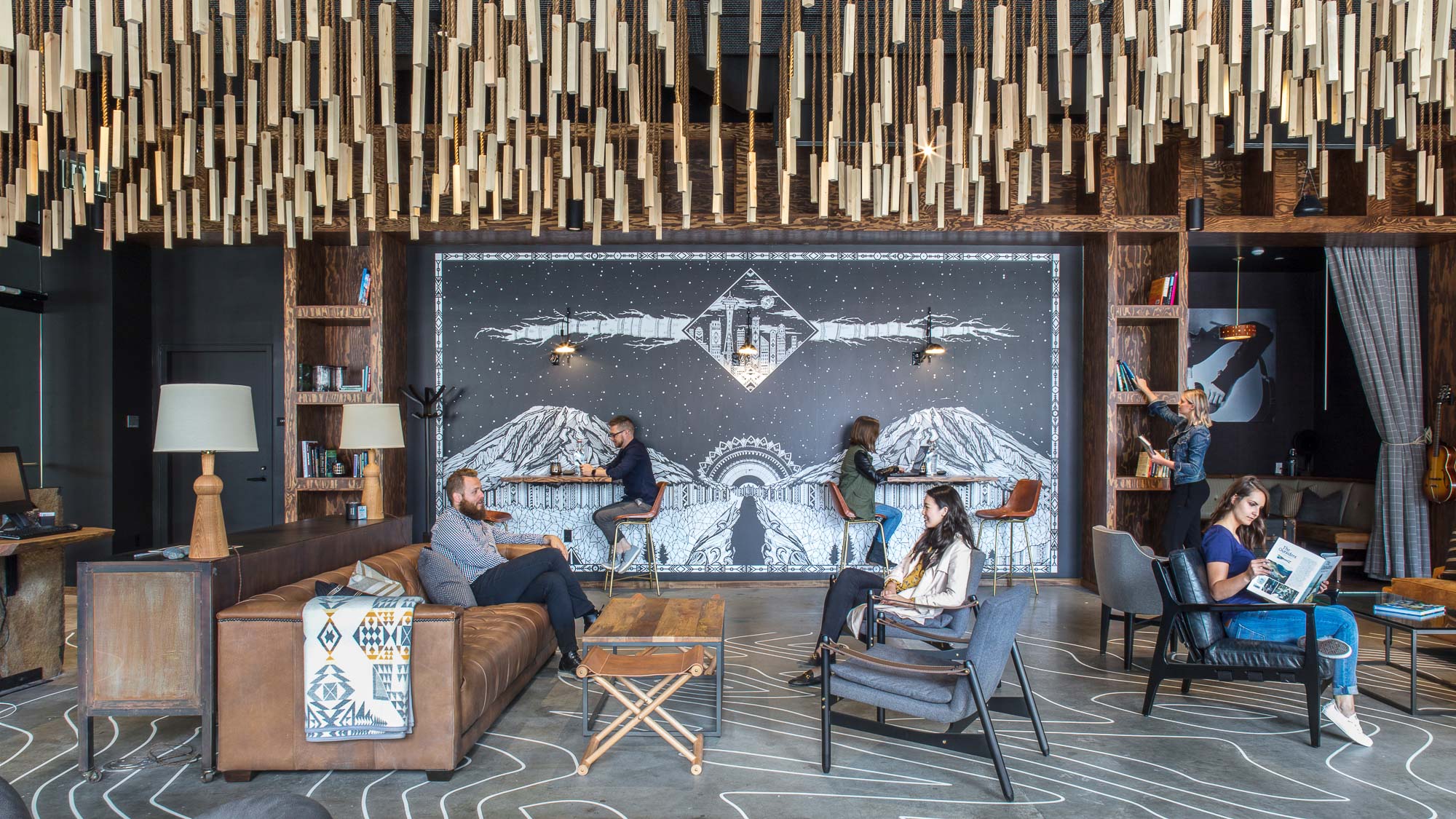 The Collective Seattle hotel lounge with hanging lights and mural